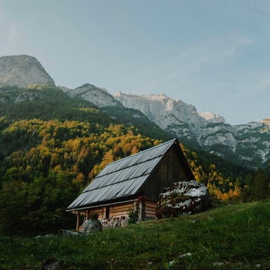 Wooden cabin against a mountain backdrop with fall foliage