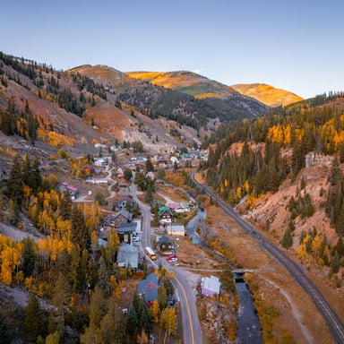 Aerial view of a Colorado mountain town nestled in fall foliage
