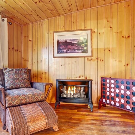 Pine cabin living room with gas fireplace and oversized wicker chair