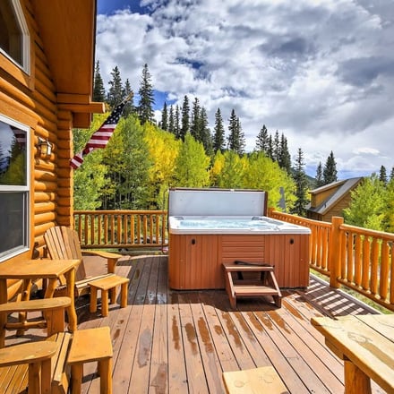 Hot tub on log deck surrounded by aspen trees turning gold in autumn
